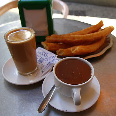Café con leche serviert mit Churros, beides Spezialitäten im spanischen und lateinamerikanischen Raum (Foto: Jun/ Flickr)